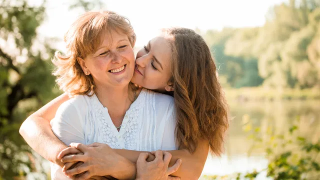 Een dochter knuffelt haar moeder.